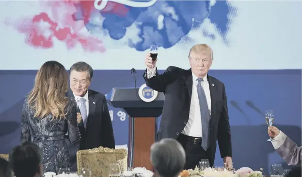  ?? PICTURE: JIM WATSON/AFP/GETTY IMAGES ?? 0 Donald Trump raises his glass as Moon Jae-in talks to First Lady Melania Trump during a state dinner in Seoul