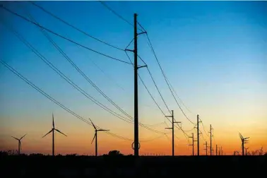  ?? TAMIR KALIFA/THE NEW YORK TIMES ?? In 2021, wind turbines and power transmissi­on lines are shown near Sweetwater, Texas. Nationwide, battery storage is being used to address renewable energy’s biggest weakness: the fact that the wind and sun aren’t always available.