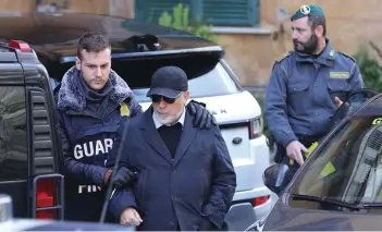  ?? —AFP ?? An Italian policeman escorts Italian Mario Di Leva, suspected of smuggling weapons to Libya and to Iran despite an embargo in San Giorgio a Cremano near Naples.