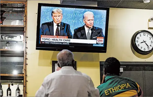  ?? ARMANDO L. SANCHEZ/CHICAGO TRIBUNE ?? People watch the first debate Tuesday between President Donald Trump and Joe Biden at Ethiopian Diamond restaurant in Chicago.