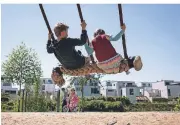  ?? FOTO: BERND THISSEN/DPA ?? Nils und Isabell schaukeln auf einem Spielplatz am Phoenixsee in Dortmund.