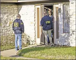  ?? AP ?? Federal agents talk to a resident in Austin, Texas, after package bombs at two homes killed a teenager and left two women wounded. A man was killed by a third package on March 2.