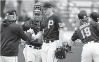  ?? GENE J. PUSKAR/AP ?? Pittsburgh Pirates pitcher Mitch Keller, center, hands the ball to manager Derek Shelton during a spring training game March 22. The Pirates are considered one of the irrelevant teams this season.