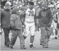  ??  ?? Cardinals guard Mike Iupati is helped off the field after an injury in the third quarter against the Green Bay Packers at Lambeau Field on Sunday.