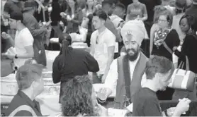  ?? ALGERINA PERNA/BALTIMORE SUN ?? Harpreet Singh Khalsa, in turban, serves up a mac and cheese recipe from The Sacred Kitchen.