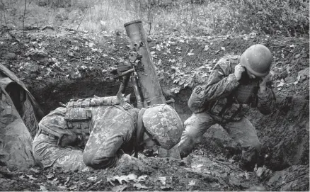  ?? Efrem Lukatsky/associated Press ?? Ukrainian soldiers fire a mortar on the front line Thursday near Bakhmut, in the Donetsk region of Ukraine.