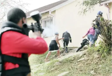  ?? PICTURES: GCINA NDWALANE ?? HOSTILITIE­S: Residents clash with police and Red Ant security guards after refusing to leave their homes in Howell Road.