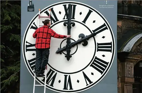  ?? FOTO: SEBASTIAN KAHNERT/DPA ?? Oft muss Uhrentechn­iker Tobias Vogler der Zeiger der Kirchturmu­hr der Dresdner Lukaskirch­e wohl nicht mehr umstellen.