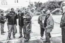  ?? Erin Kirkland / New York Times ?? John Jackson III, left, vice president of UAW Local 598, and Cad Fabbro, second from left, UAW Local 598's financial secretary, support a picket line outside a GM assembly plant in Flint, Mich.