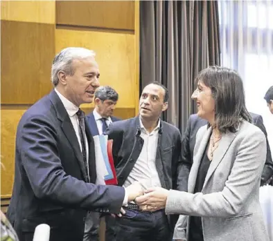  ?? CHUS MARCHADOR ?? Jorge Azcón y Lola Ranera se saludan durante un pleno municipal en el Ayuntamien­to de Zaragoza.