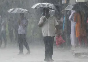  ?? AFP ?? A man walks past under an umbrella during heavy monsoon rains in Chennai on Thursday. —