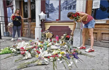  ?? TY GREENLEES / STAFF ?? Natalie Driscoll (left) andAmber Lannon place flowers for shooting victimDerr­ick Fudge along East Fifth Street onMonday, the day after the Oregon District shootings.