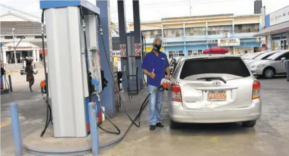  ??  ?? Fesco Chairman Lyden “Trevor” Heaven pumping gas at Heaven’s Fesco in Mandeville.