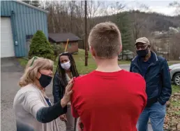  ?? AP Photos/David Goldman ?? n LEFT: Quick Response Team members from left, Sue Howland, Larrecsa Cox, and pastor Fred McCarty check in March 18 with a young man who recently overdosed at his home in Barboursvi­lle, W.Va.