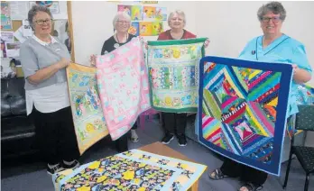  ?? ?? Robyn McDougal (midwifery team leader) with Cottage Quilters Diana Morris and Jacqui Balaam and Louise Jensen (maternity administra­tion) hold some of the 11 quilts donated for newborns.