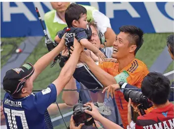  ?? FOTO: ASFOURI/AFP ?? Japans Torhüter Eiji Kawashima nimmt seinen Sohn Kensei auf den Arm und freut sich mit ihm über das Erreichen des Achtelfina­ls – weil die Asiaten weniger Gelbe Karten als Senegal kassiert haben.