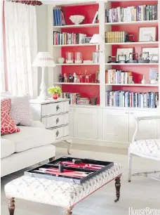  ??  ?? The glossy red wall behind the shelves livens up the display and makes it a focal point in this all-white room.