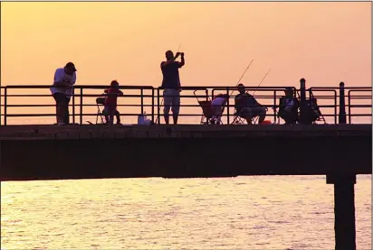  ??  ?? A group of anglers enjoying their day while fishing at Souq Sharq. (Noura Edhbayah – KUNA)