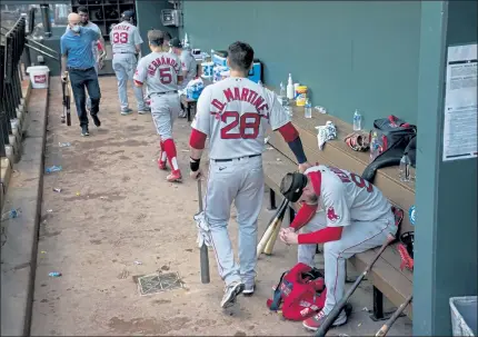  ?? AP PHOTOS ?? The Red Sox dugout empties on Sunday evening in Arlington, Texas, after blowing a late lead against the Rangers to lose, 5-3. Below, Rafael Devers lets a little dribbler get past him.