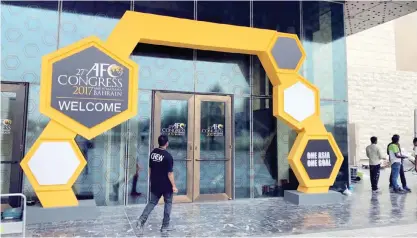  ?? — AP ?? MANAMA: A member of staff walks towards the building hosting the AFC, Asian Football Confederat­ion Congress 2017, in Manama. The specter of fresh corruption scandals hangs over the annual gathering of world soccer leaders, two years after the FIFA...