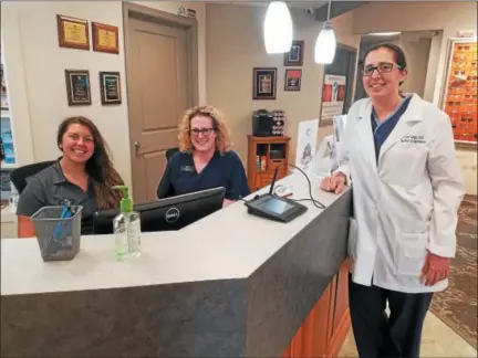  ?? DONNA ROVINS — DIGITAL FIRST MEDIA ?? Dr. Lori Gray, right, opened her optometric practice — Complete Family Eyecare on Swamp Road in New Hanover 10 years ago. The practice has grown and now boasts five doctors and eight exam rooms. In this photo, staff members Cait Somerville, left and Janice Miuccio, center boasts with two members of staff