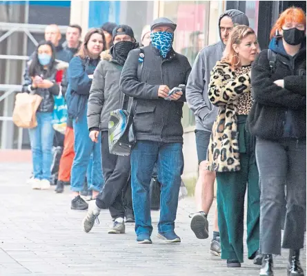  ?? Pictures: SNS Group/Kim Cessford. ?? People queuing up outside a shop in Glasgow while, right, someone put a protective mask on the statue of Hamish McHamish, St Andrews’ famous cat.