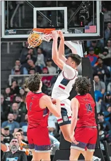  ?? HANS PENNINK/AP PHOTO ?? UConn’s Donovan Clingan (32) dunks in front of Saint Mary’s Harry Wessels (1) and Kyle Bowen (14) during Sunday’s NCAA tournament game in Albany, N.Y. The Huskies rolled to a 70-55 victory.