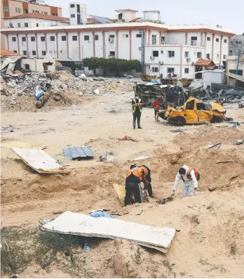  ?? AFP VIA GETTY IMAGES ?? Workers at the mass grave found near the Nasser Medical Complex in the Gaza Strip on Thursday.