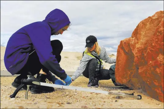  ?? BRETT LE BLANC/LAS VEGAS REVIEW-JOURNAL @BLEBLANCPH­OTO ?? Jessica Smith, 39, right, and Hailey Kervick, 14, clean up trash while volunteeri­ng Saturday at the Sunrise Trailhead in the Clark County Wetlands Park during a Martin Luther King day of service.