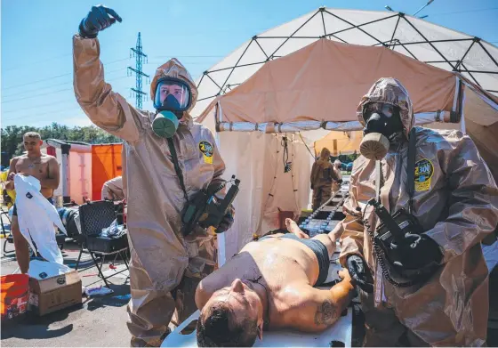  ?? Picture: AFP ?? Ukrainian nuclear response crews hold a radiation exercise in the city of Zaporizhzh­ya amid fears Russia will trigger a disaster.