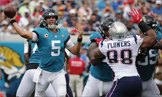  ?? STEPHEN B. MORTON — THE ASSOCIATED PRESS ?? Jacksonvil­le Jaguars quarterbac­k Blake Bortles throws a pass as he is pressured by New England Patriots defensive end Trey Flowers (98) during a Sept. 16, 2018 game. A free agent, Flowers has visited the Patriots.