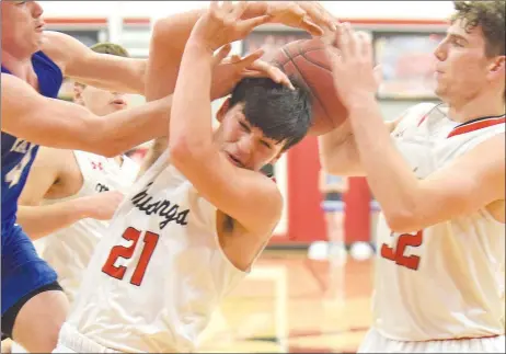  ?? RICK PECK/SPECIAL TO MCDONALD COUNTY PRESS ?? McDonald County’s Jackson Clarkson gets in the middle of a battle between Carthage’s Tyler Mueller and McDonald County’s Cade Smith for a rebound during the Tigers’ 70-34 win on Dec. 19 at MCHS.