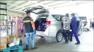  ?? Photo by Rizk Taufiq ?? Goods being loaded in a car to be delivered at home.