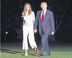  ??  ?? El presidente Donald Trump y la primera dama Melania, al descender del helicópter­o presidenci­al en los jardines de la Casa Blanca, en Washington.