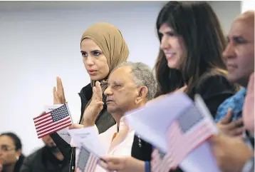  ?? — GETTY IMAGES ?? Immigrants take the oath of citizenshi­p in Newark, N.J. Although much of the federal government was shut down Monday morning, Citizenshi­p and Immigratio­n Services offices remained open nationwide.