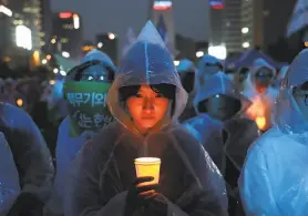  ?? Chung Sung-Jun / Getty Images ?? South Koreans attend a peace rally in Seoul before the U.S. and North Korea summit. President Trump and Kim Jong Un are to meet Tuesday in Singapore.