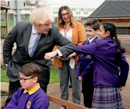  ?? AFP ?? British Prime Minister Boris Johnson bumps elbows with a student during his visit to St Mary’s C.E. Primary School in Stoke-on-Trent, England, on Monday. —