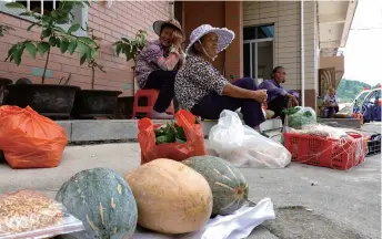  ??  ?? Villagers waiting to sell home-grown agricultur­al products to tourists in Junying on September 9