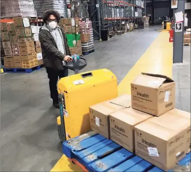  ?? Luther Turmelle / Hearst Connecticu­t Media ?? Scott Kemp moves boxes of COVID-19 home tests at Connecticu­t Food Share in Wallingfor­d.