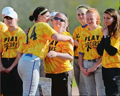  ?? SARAH GORDON/THE DAY ?? Waterford’s Marissa Walker (14) hugs Stonington’s head coach Ann-Marie Houle before the annual Play4TheCu­re softball game on Monday at Stonington. Please go to theday.com to view a photo gallery from the game.