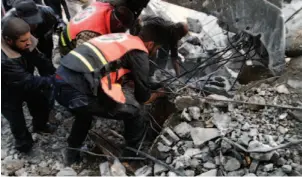  ?? AP PHOTO ?? Palestinia­ns pull a body of a child from under the rubble of the Daloo family home following an Israeli air strike in Gaza City on Sunday.