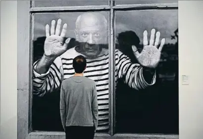  ?? LLUIS GENE / AFP ?? Un visitant contempla la icònica imatge de Picasso amb samarreta de mariner captada per Robert Doisneau