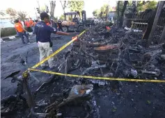  ??  ?? A man looking at burnt-out motorcycle­s following a bomb blast outside the Surabaya Centre Pentecosta­l Church (Surabaya Gereja Pantekosta Pusat) on May 13.— AFP photo