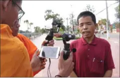  ?? SUPPLIED ?? Land rights activist Kuch Veng speaks to two monks after being questioned at the Pursat Provincial Court yesterday.
