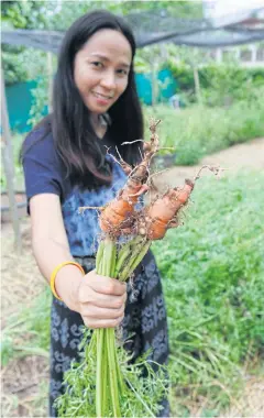  ??  ?? Nutpavee holds organic carrots used as ingredient­s for herbal skincare products.
