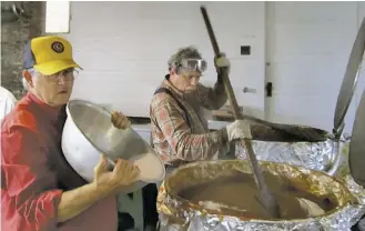  ?? COURTESY PHOTO ?? Roger Welch pours sugar and Jim Blubaugh stirs as the Rappahanno­ck Lions Club makes another annual batch of tasty apple butter.