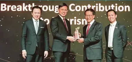  ??  ?? Genting Hong Kong chairman and chief executive officer Tan Sri Lim Kok Thay (second from right) receiving the ‘Breakthrou­gh Contributi­on to Tourism’ award from Singapore Trade and Industry Minister Chan Chun Sing at the award ceremony in Singapore yesterday. With them are (from left) Singapore Tourism Board chairman Chaly Mah and chief executive officer Keith Tan.