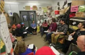  ?? MIKE GROLL — THE ASSOCIATED PRESS ?? In this Tuesday photo, workers attend a quarterly produce staff meeting at Honest Weight Food Co-Op in Albany, N.Y. Food cooperativ­e programs that allow members to scoop rice, sort organic vegetables and ring up sales in return for grocery discounts...