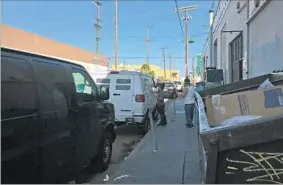  ?? Natalie Kitroeff Los Angeles Times ?? GARMENT workers cash checks at an unmarked van in downtown L.A.. In some cases, employers issue vouchers cashable only at the vans parked outside factories.