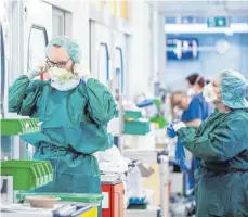  ?? FOTO: MARCEL KUSCH/DPA ?? Krankenpfl­eger vor einem Zimmer auf der Intensivst­ation des Universitä­tsklinikum­s Essen: Auch Angestellt­e in Krankenhäu­sern sollen nun mit einer Einmalzahl­ung belohnt werden.